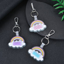Close-up view of silver metal split ring and swivel spring lobster clasp mechanism on custom rainbow cloud charm.