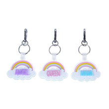Trio of personalized pastel rainbow acrylic cloud keychains with purple, pink, and blue glitter names on white background.