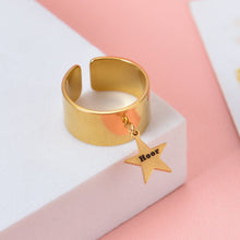 Gold custom open cuff wide band ring featuring a dangling star charm engraved with text Hoor.