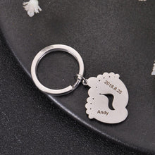 Silver personalized baby footprint keychain engraved with a baby's name and birth date.