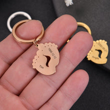 Close-up of an engraved baby feet keychain showing the personalized baby's name and birth date.