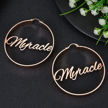 Rose gold custom round hoop earrings featuring script nameplate Myracle centered across the inner circle frame.