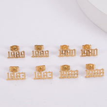 Eight gold-tone stud earrings with different years engraved on them.