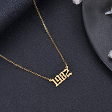 Gold personalized birth year necklace featuring a custom year in bold Old English font.