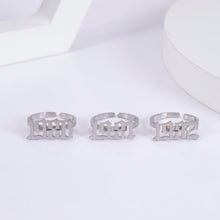 Personalized birth year rings displayed together as custom number jewelry gifts for birthdays and milestones.