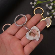 Hand holding gold custom heart picture keychain attached to car key set for size demonstration.