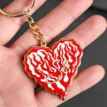 Person holding a colorful personalized heart photo keychain with custom picture