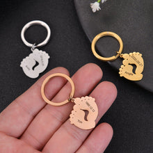 Close-up of an engraved baby feet keychain showing the personalized baby's name and birth date.