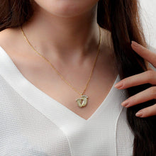 Woman wearing a personalized baby feet necklace with a custom engraved baby name pendant.