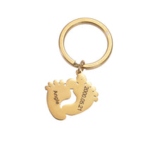 Gold personalized baby feet keychain with custom engraved name and date for a new parent.