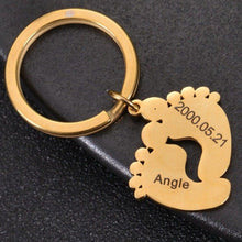 Gold personalized baby feet keychain with custom engraved name and date for a new parent.