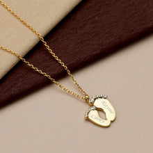 Close-up of a personalized baby feet pendant showing custom engraved names on the tiny footprint charms.