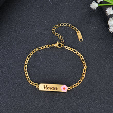 Close-up of Gold lobster claw clasp and Figaro style chain links on personalized name bar bracelet.