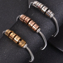 Grouping of gold, silver, and rose gold custom charm beads showing modular threadable cylinder bead design.