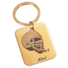 Football player carrying a personalized helmet keychain with their name and jersey number.