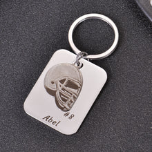 Silver personalized football helmet keychain featuring a custom player's name and number.