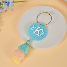 Blue acrylic initial keychain with multicolor tassel