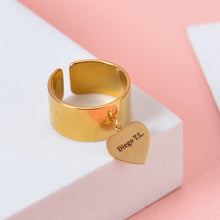 Gold personalized wide cuff ring with a dangling heart charm custom engraved with text Diego T.L.