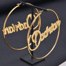 Close-up view of gold custom retro cursive nameplate BabyDe showing clean laser-cut letter edges and wire attachment points.