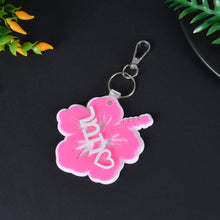 Pink acrylic hibiscus flower keychain featuring custom white overlay script name Mini and heart accent motif.