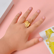 Person wearing gold custom wide band open cuff ring with dangling charm for lifestyle scale and fit perspective.