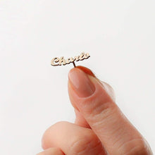 Side angle view highlighting flat profile and smooth curved contours of gold script nameplate stud.