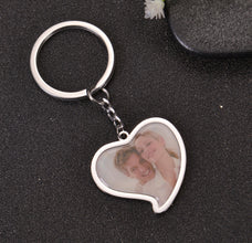 Close-up view of silver heart photo charm highlighting printed picture quality and rounded frame rim.