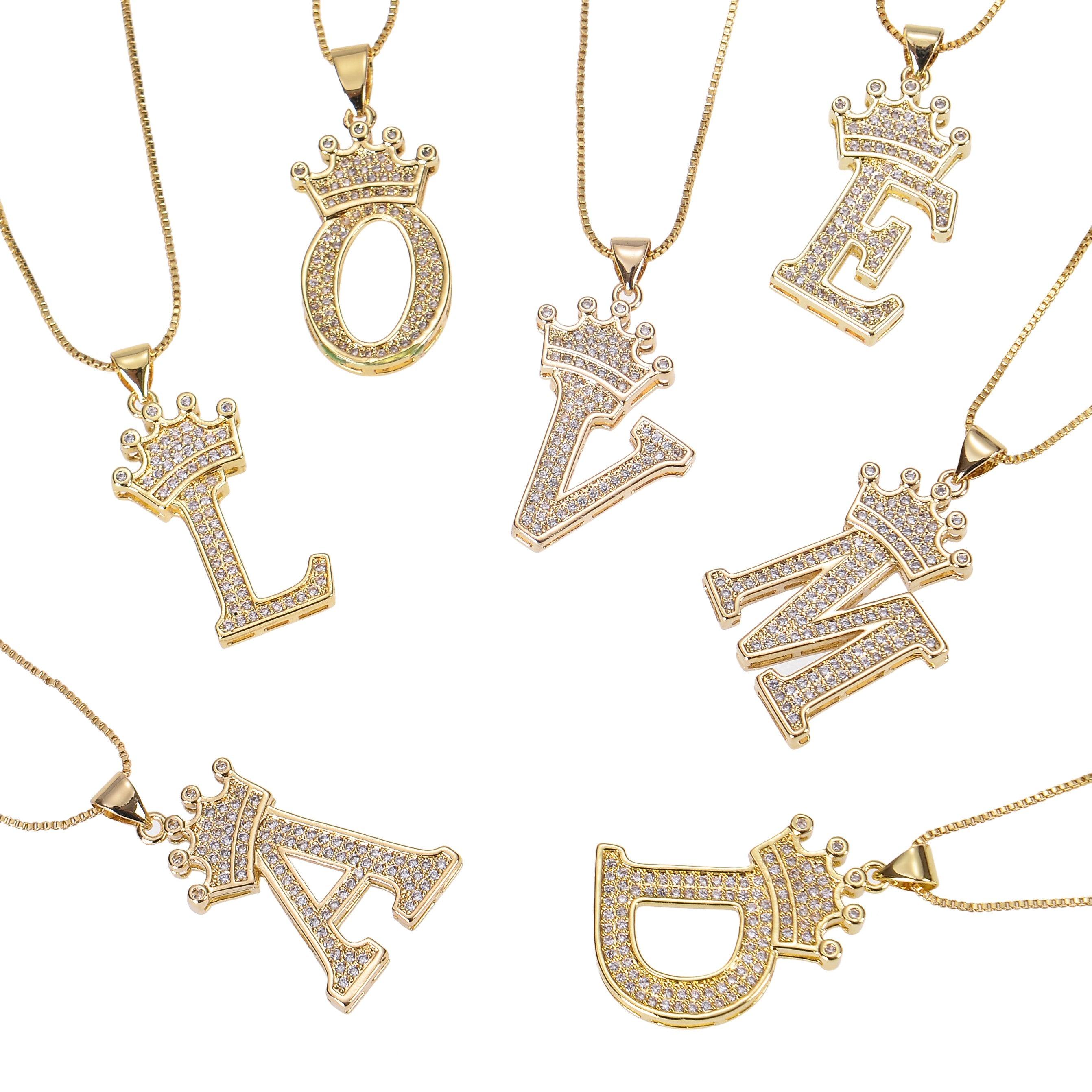 A set of gold necklaces with letter pendants and crowns. Each pendant is encrusted with clear rhinestones. The letters are L, O, V, E, M, A, and D.