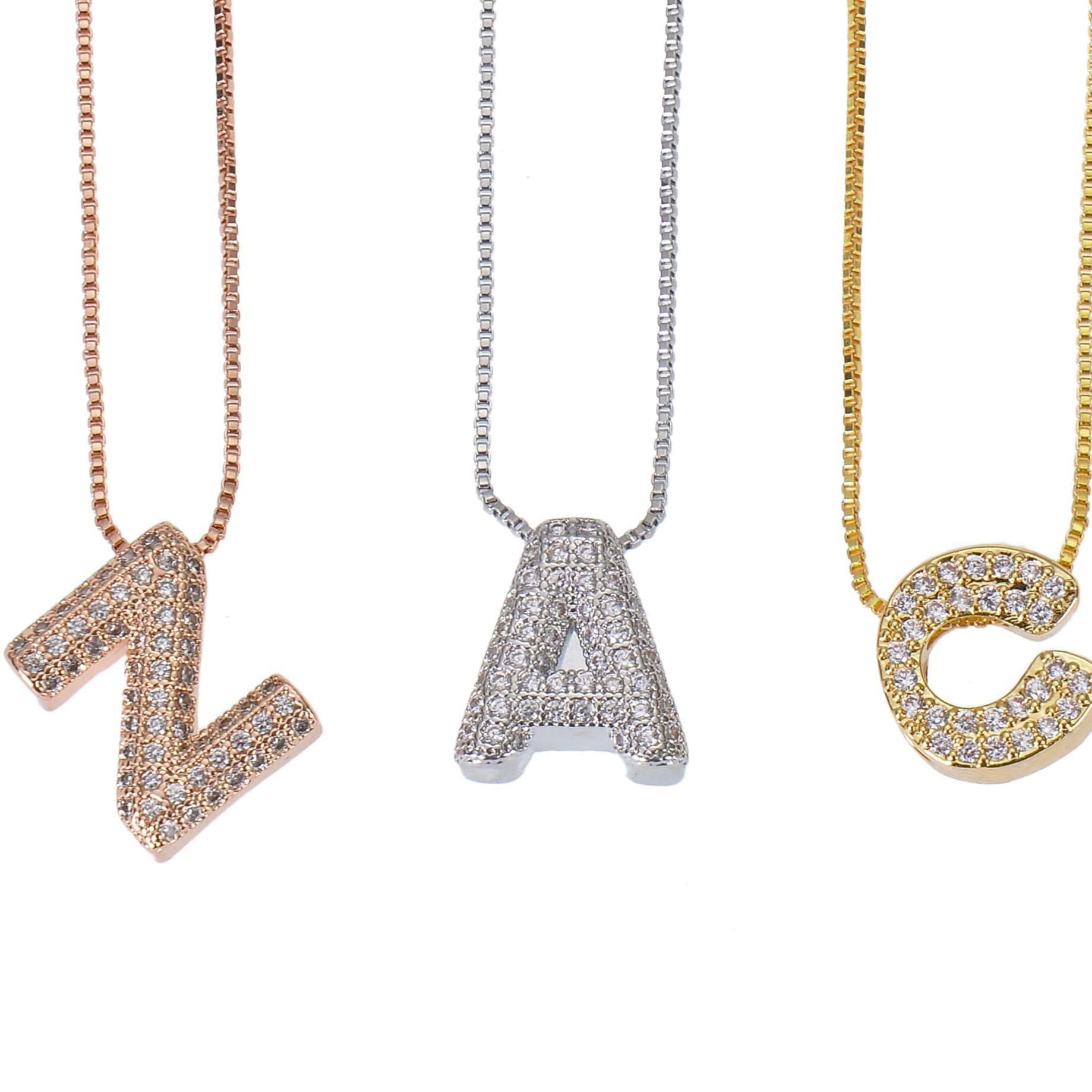 Multiple bold initial necklaces laid out together