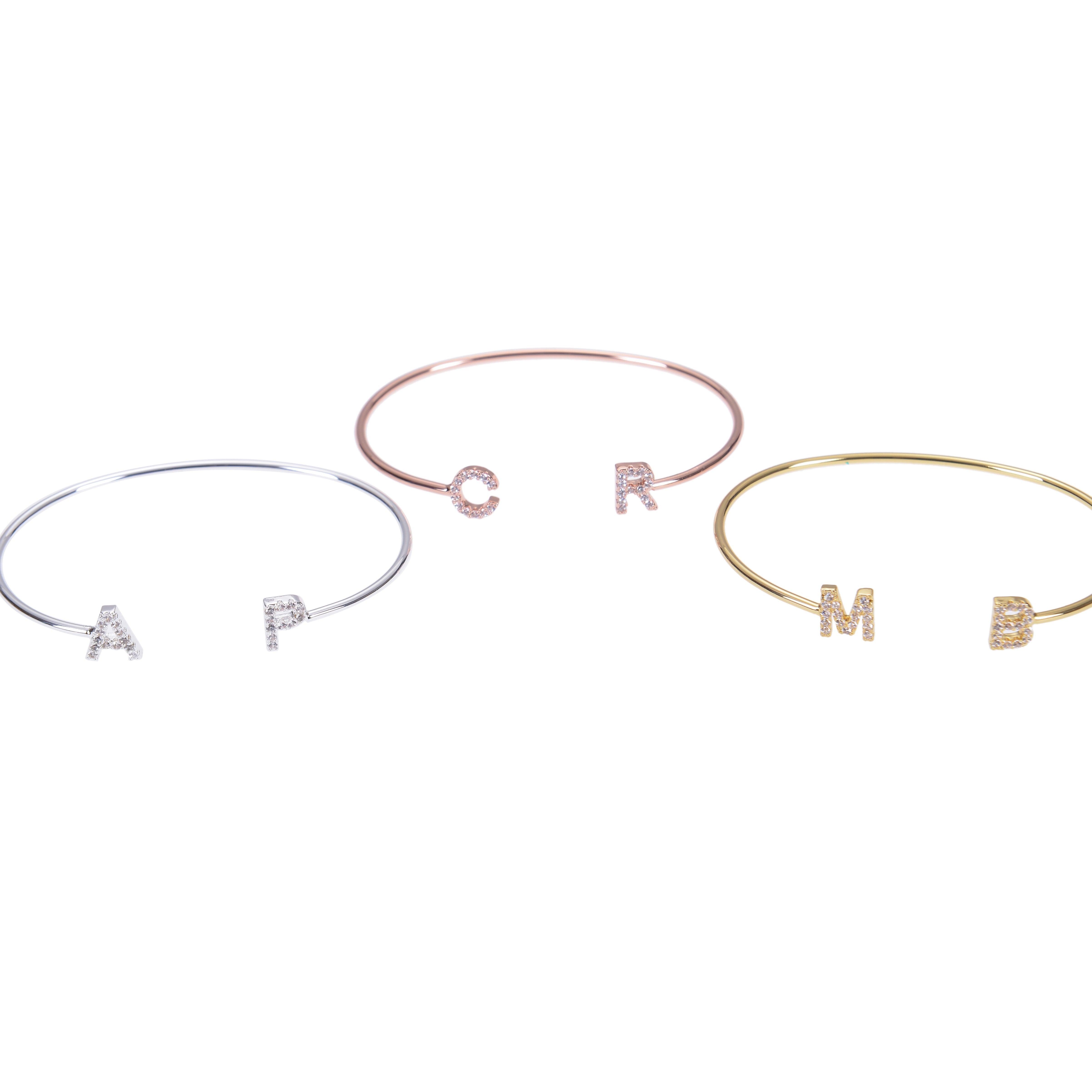 Multiple initial letter bangles laid out together