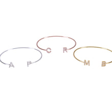 Multiple initial letter bangles laid out together
