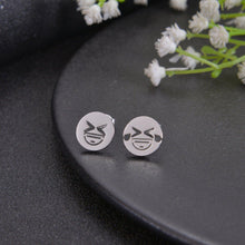 Silver emoji stud earrings with winking face design