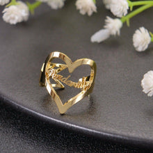 Gold custom open-heart name ring featuring cursive script word across the open frame.