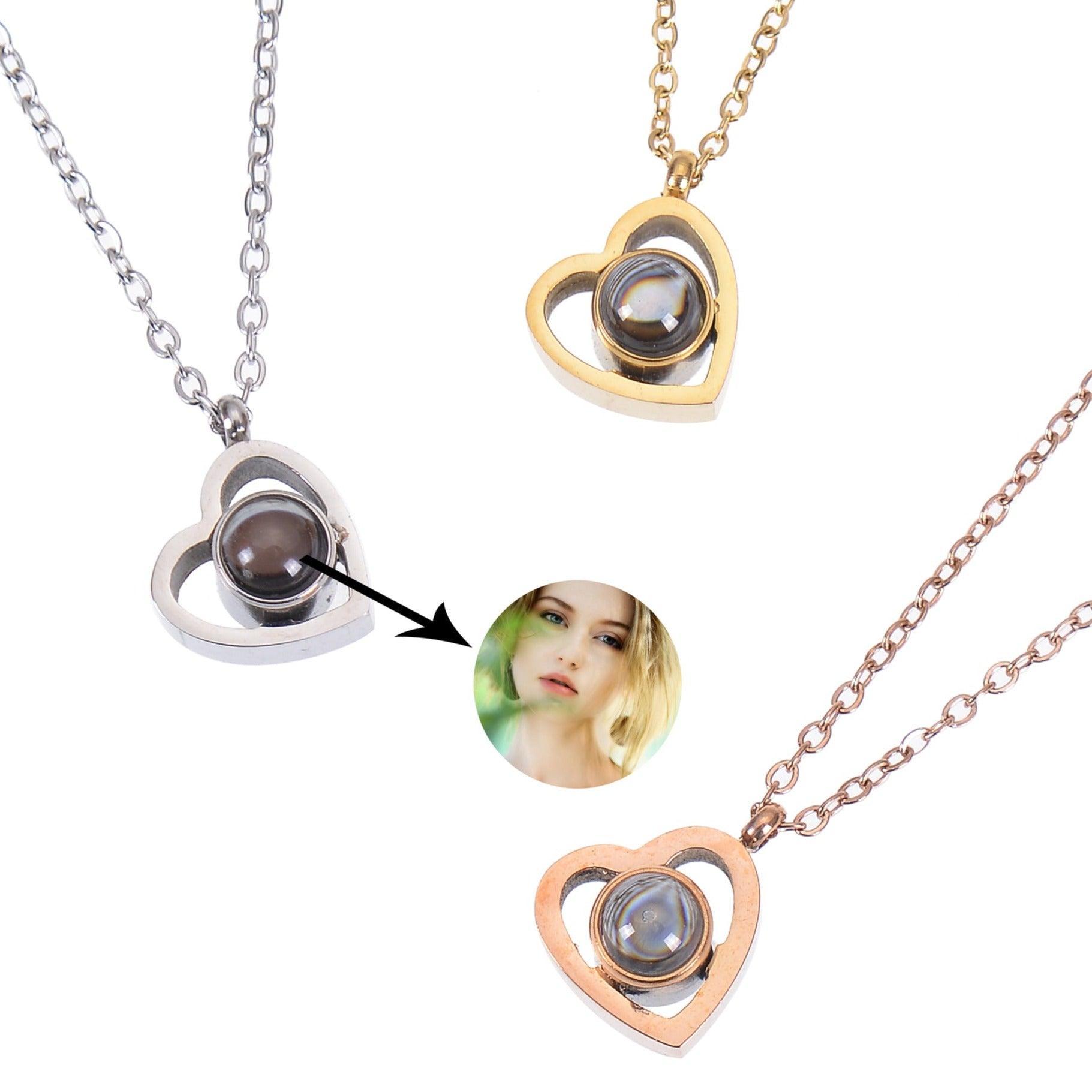 Two silver and gold heart-shaped necklaces with a small round projection in the center. The projection is a holographic image that changes when viewed from different angles.