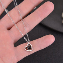 Close up of silver heart necklace featuring a custom photo pendant