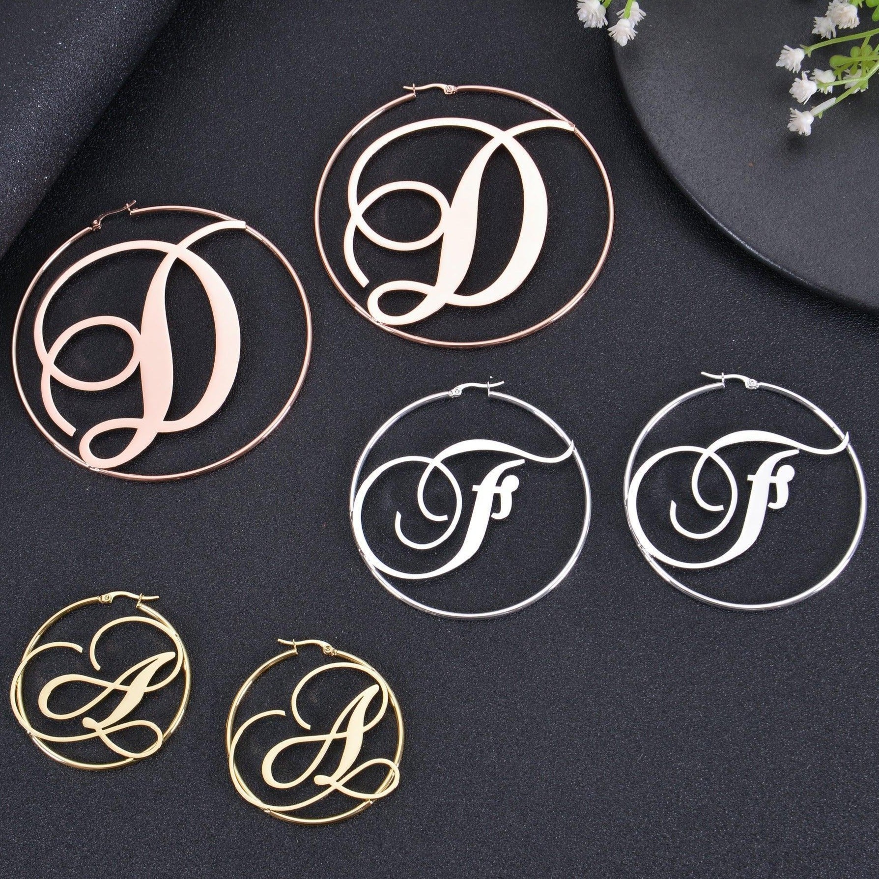 Hinged hoop and clasp detail on script initial earring
