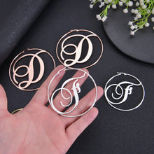 A person holding a initial letter hoop earrings