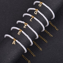 Multiple pearl initial bracelets stacked together