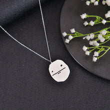 Silver meme pendant necklace with humorous face engraving