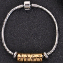 Gold personalized cylinder name beads grouped together on silver snake chain bracelet with secure clasp.