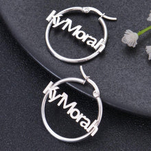 Small silver personalized hoop earrings featuring custom Old English gothic typography nameplate Sxhrting.