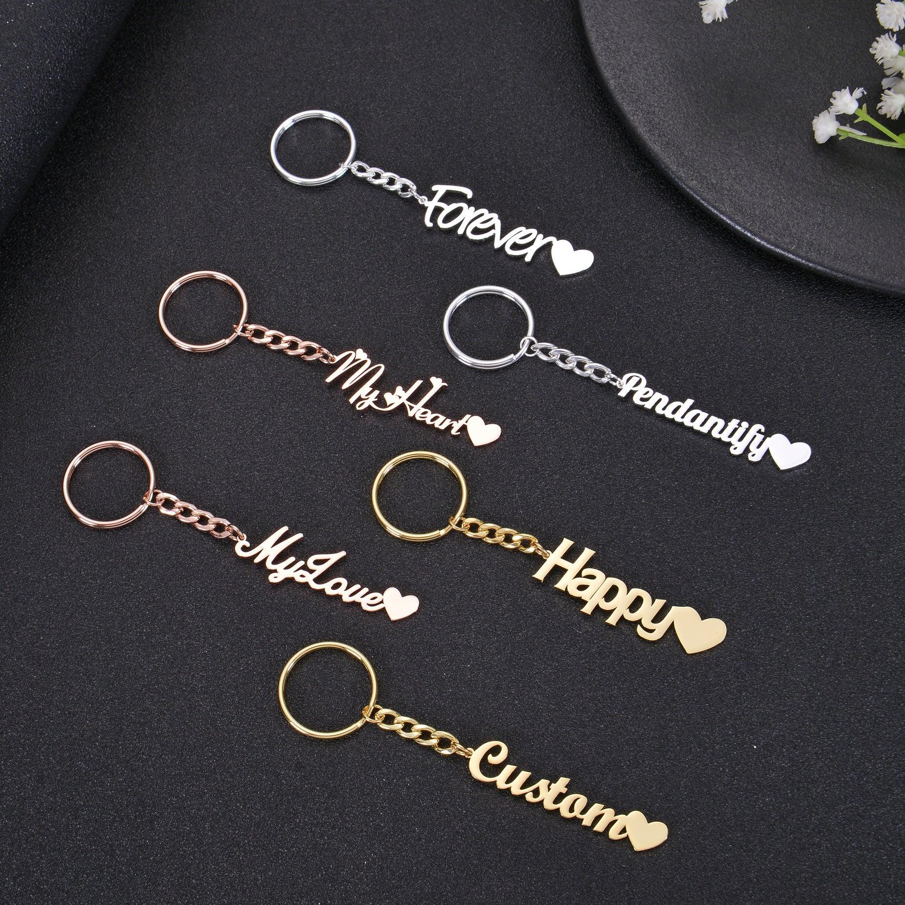 Pendantify personalized name keychain featuring custom cursive script nameplate ending with a solid heart charm tail in gold, rose gold, and silver.