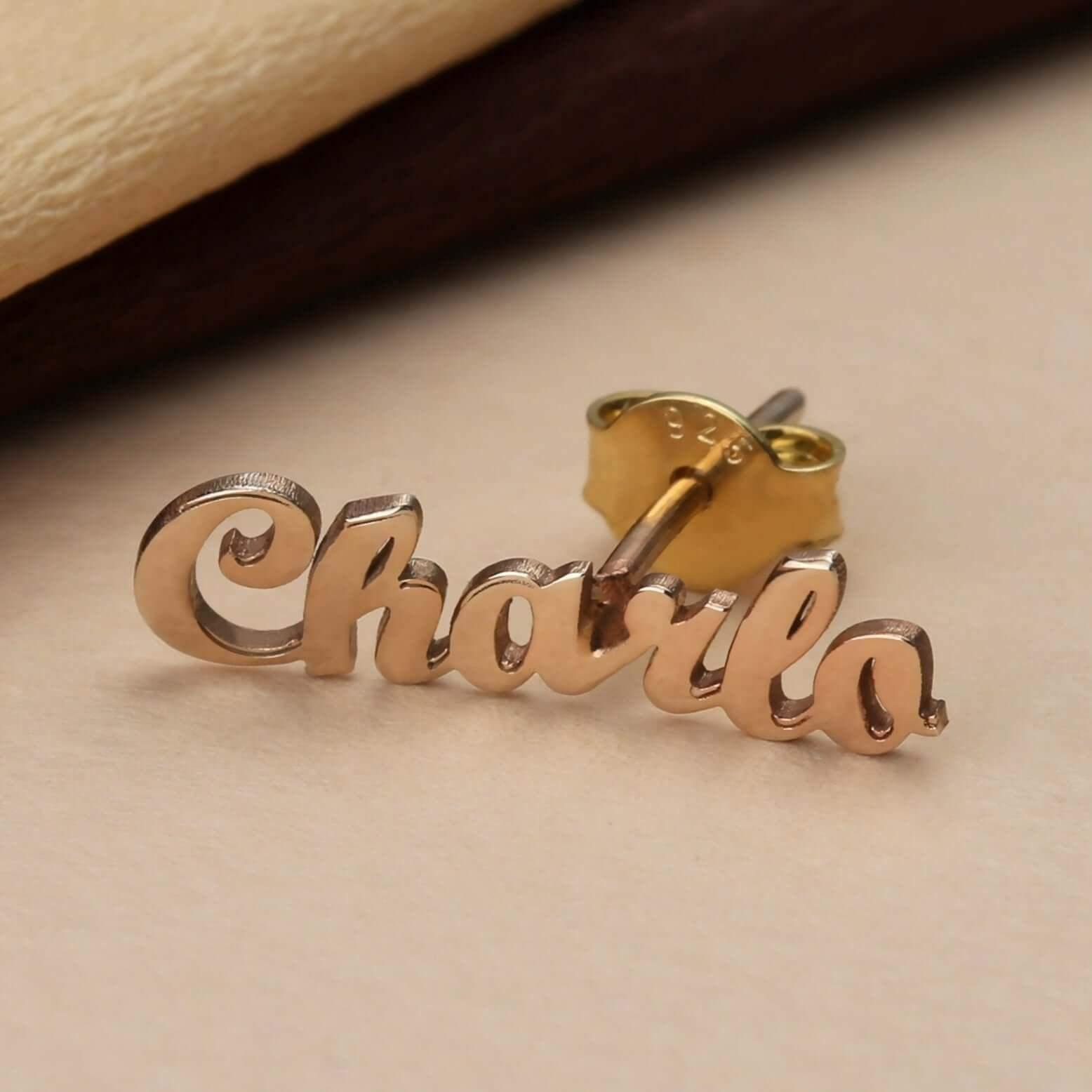 Close-up macro view of gold personalized name stud earring Charla showing detailed laser-cut cursive lettering.