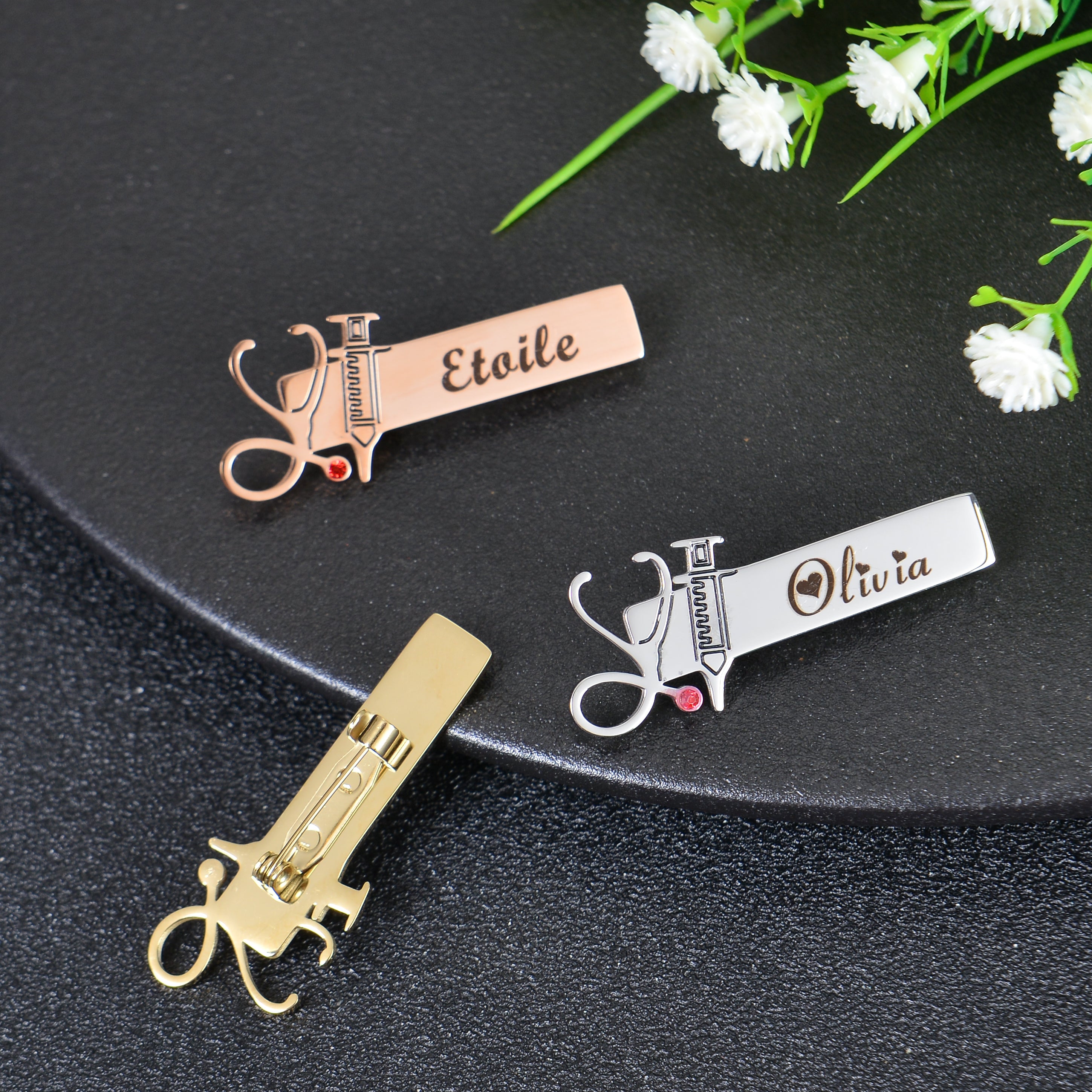 Pendantify personalized nurse brooch pin featuring custom engraved name plate with integrated stethoscope and syringe charms in rose gold, silver, and gold.