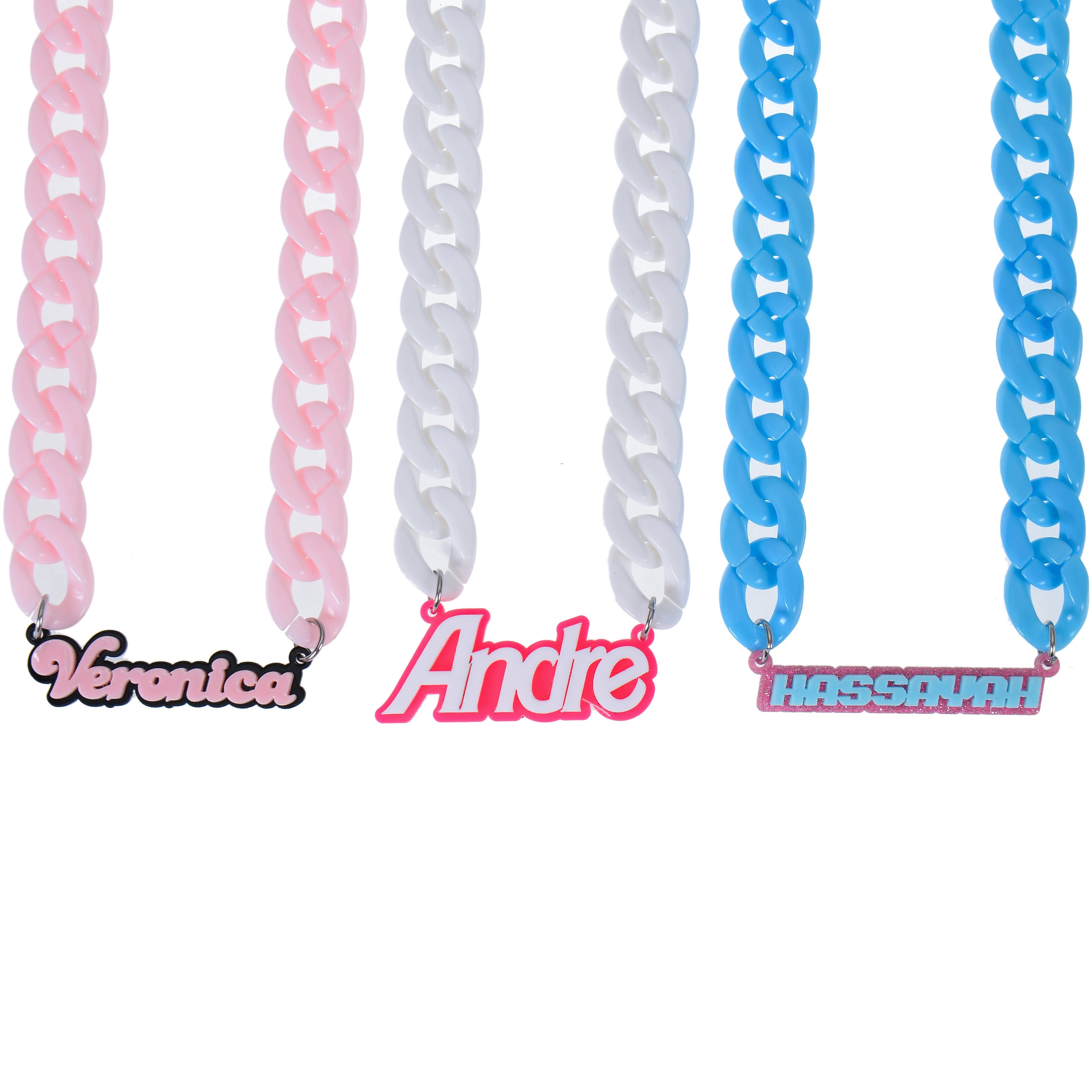 Pink, blue, and white acrylic name necklaces shown together