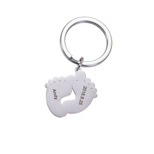 Silver personalized baby footprint keychain engraved with a baby's name and birth date.