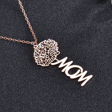 Close-up of personalized rose birth flower charm attached to custom cursive script name pendant.