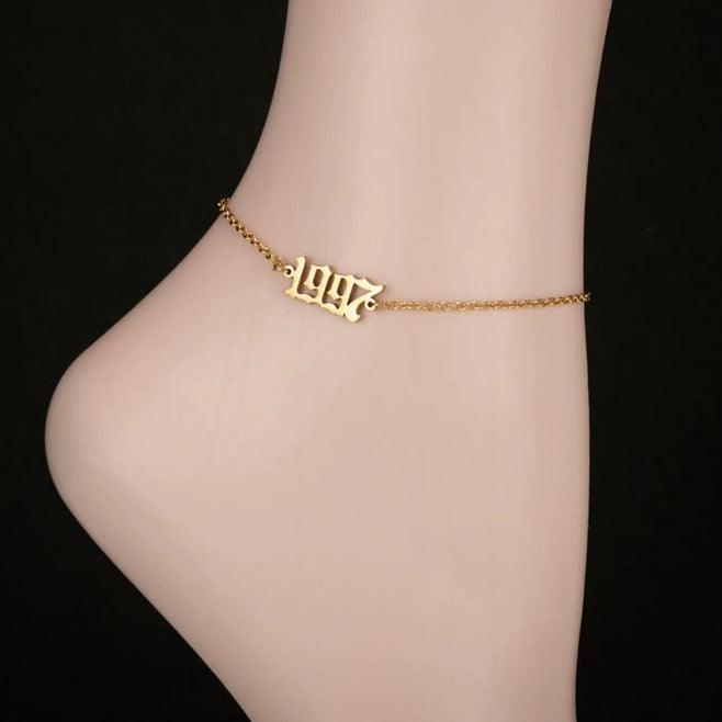 Gold custom year anklet styled as a personalized birthday or milestone gift for her.