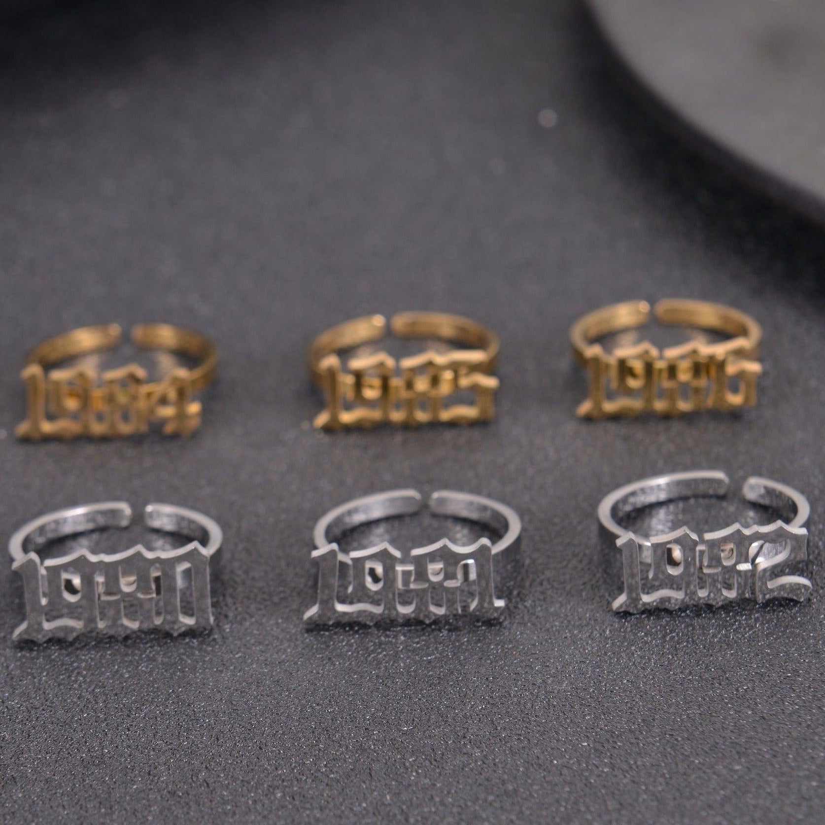 Gold, Silver, and Rose Gold personalized birth year rings displayed together.