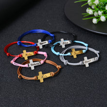 Adjustable cord and clasp detail on cross bracelet